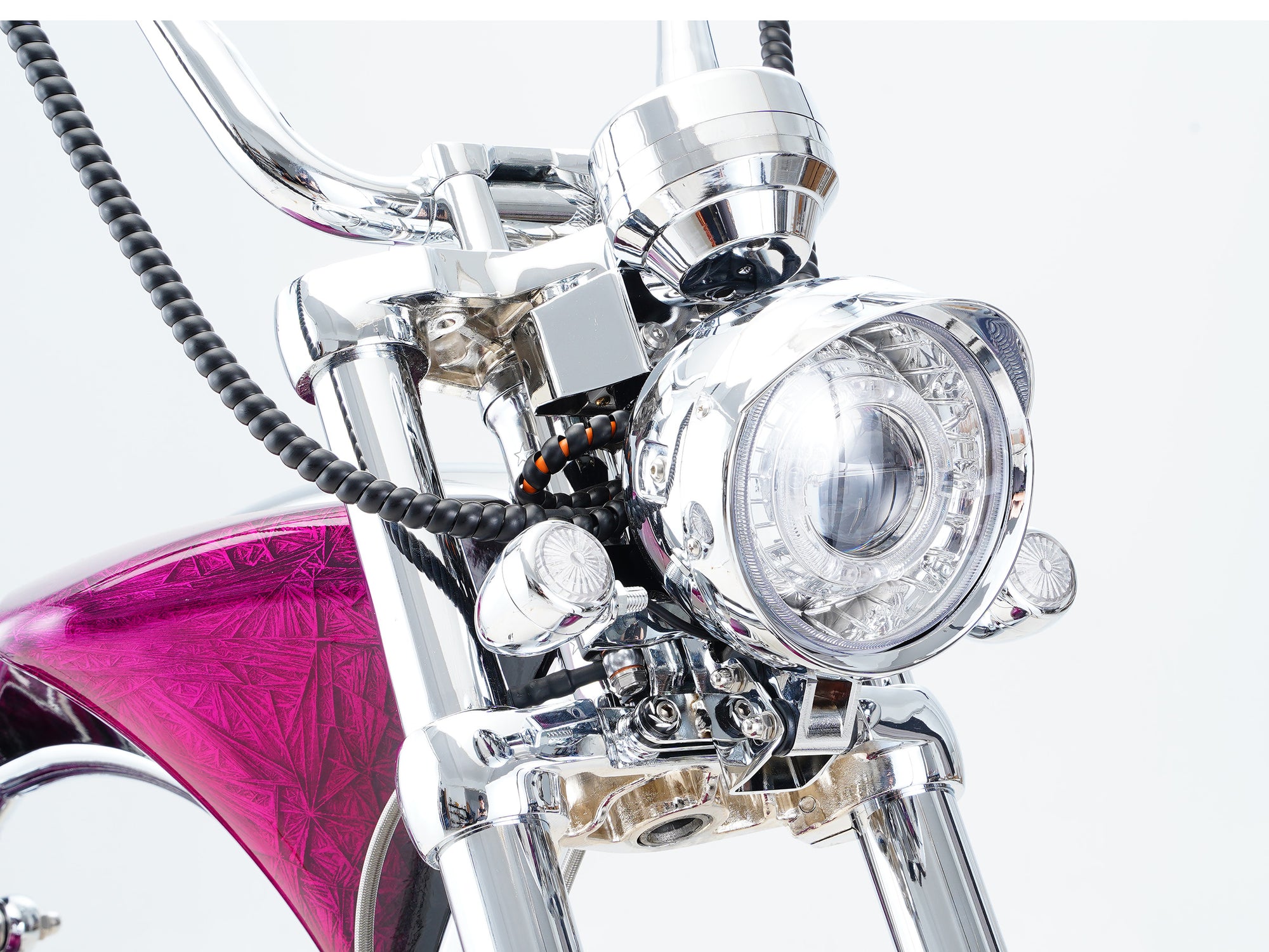 Up-close shot of the vintage-style headlight assembly for a chopper electric motorcycle